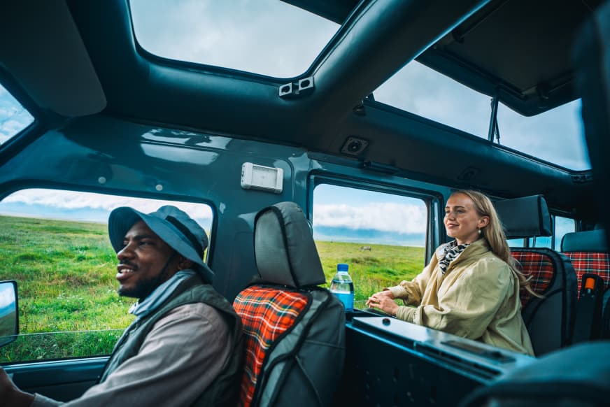 Safari guide and guest in a private vehicle on the plains