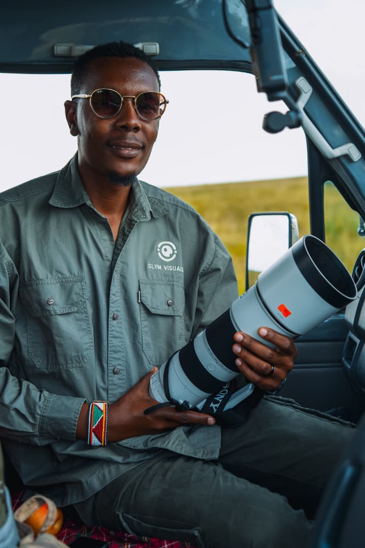 Photographer in a private safari vehicle holding a camera