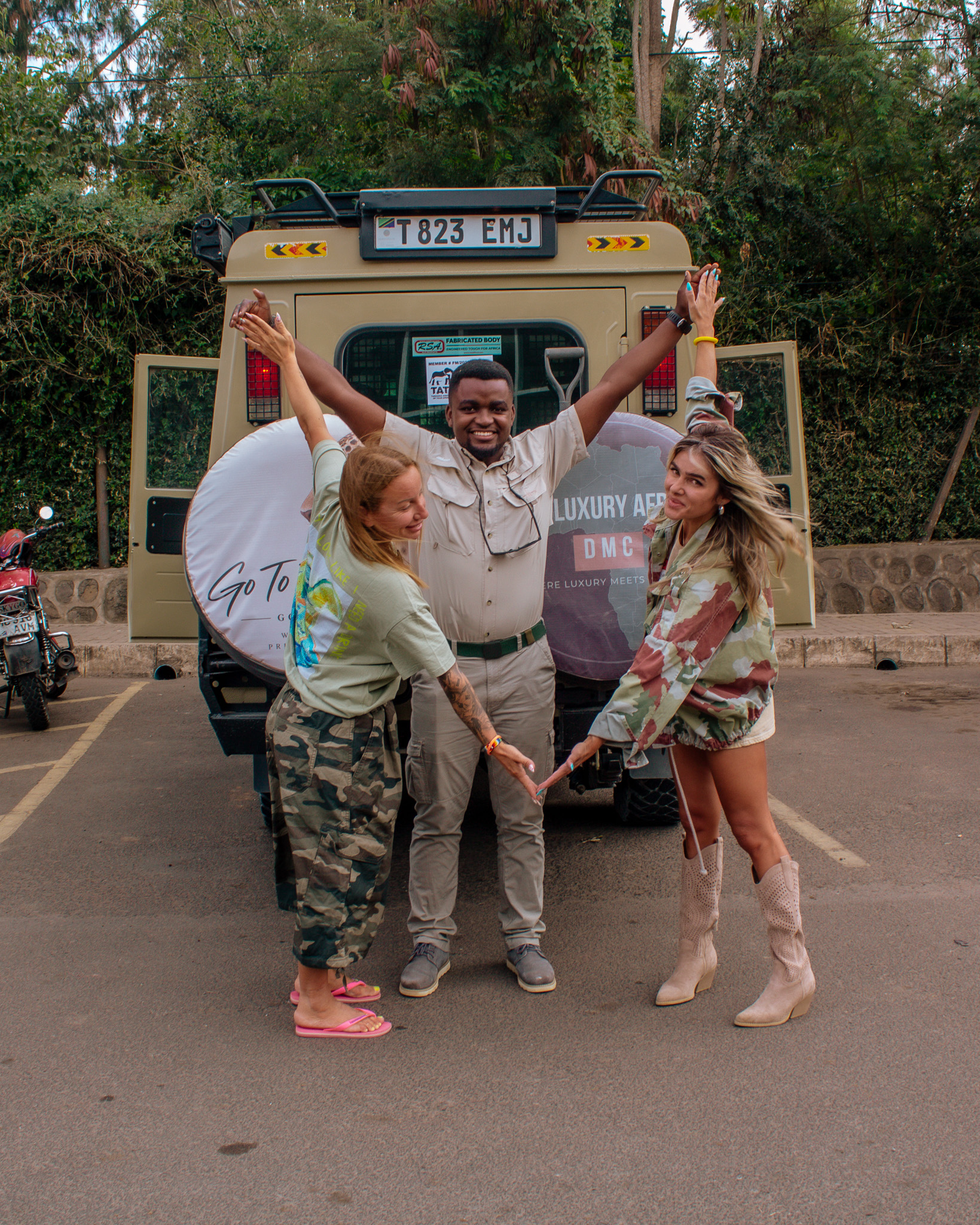 Guide welcoming guests beside a branded Luxury Africa DMC safari vehicle